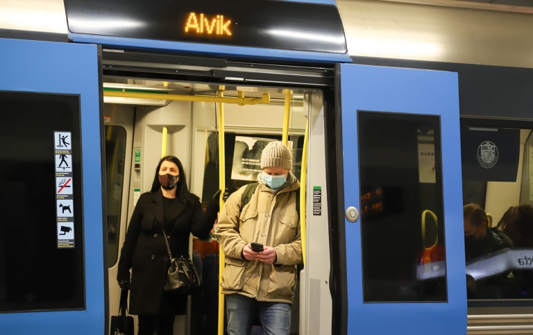 Two commuters wearing face masks in the Stockholm underground.